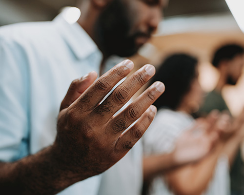 Black man praying with hands open in Thanksgiving