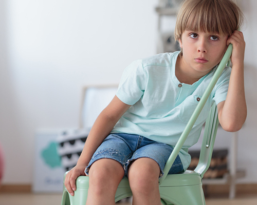 Sad boy in chair ADHD
