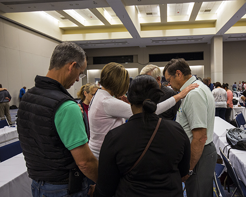 A participant of the anointing service prays over a fellow educator in her small group. 