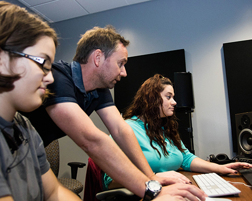 Kyle Portbury and two students edit films at Southwestern Adventist University