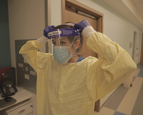 Wamack putting on PPE