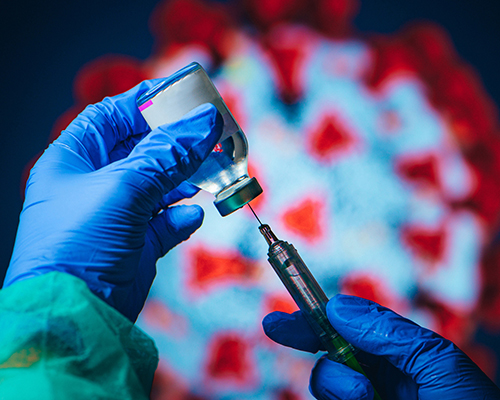 stock photo of coronavirus model and vaccine needle