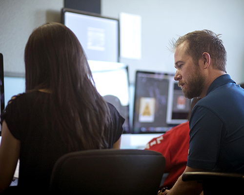 male professor and female student looking at computer