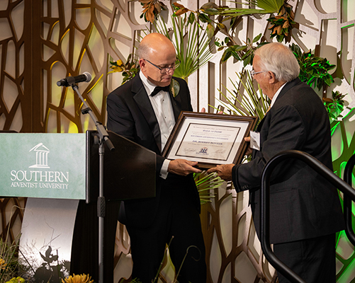  The Tennessee Independent Colleges and Universities Association (TICUA) Inductee Robert Bowers receives his Hall of Fame certificate from Ken Shaw, Southern Adventist University president.
