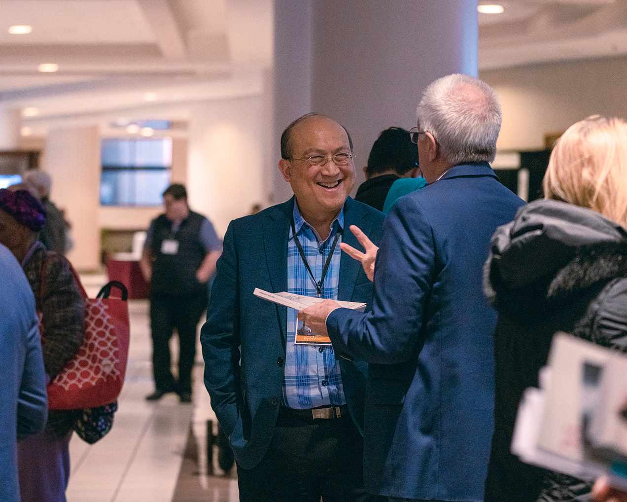 Friends laughing together in the exhibit hall of the North American Division's Adventist Ministries Convention
