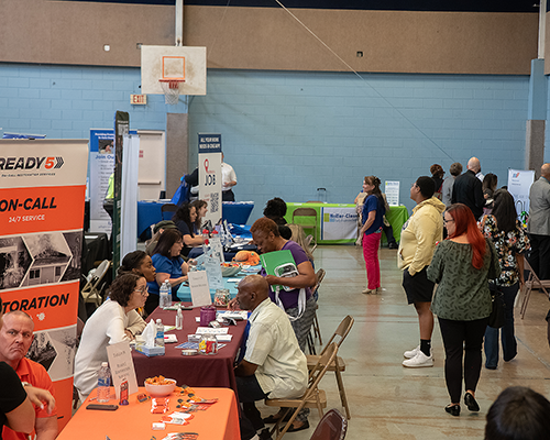 A photo of a job fair in a gym