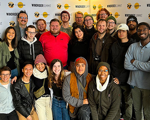 Group photo in front of a step and repeat.
