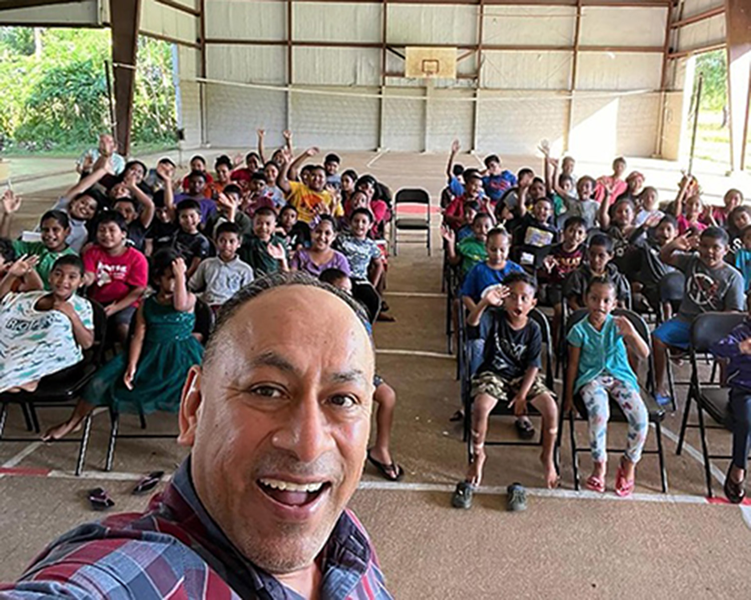 Man taking selfie with young people.