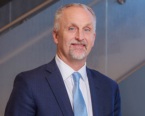 Man in suit smiling at camera.