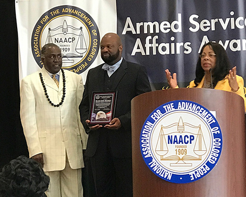 three people standing on a stage in front of a podium