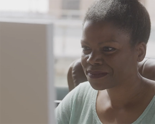 stock image of middle age black woman gazing at computer screen