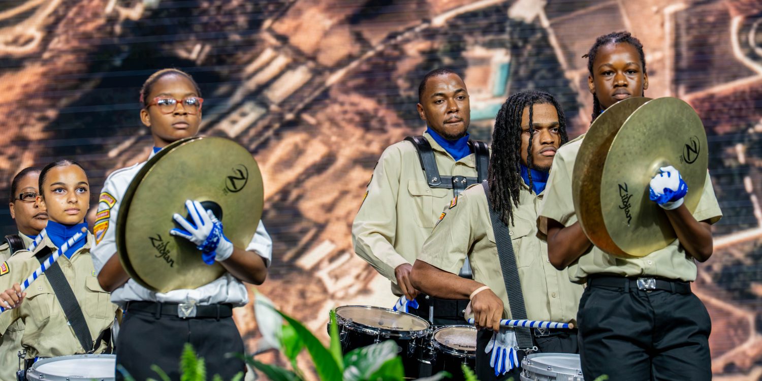 Pathfinders and leaders play drums on the General Conference stage.