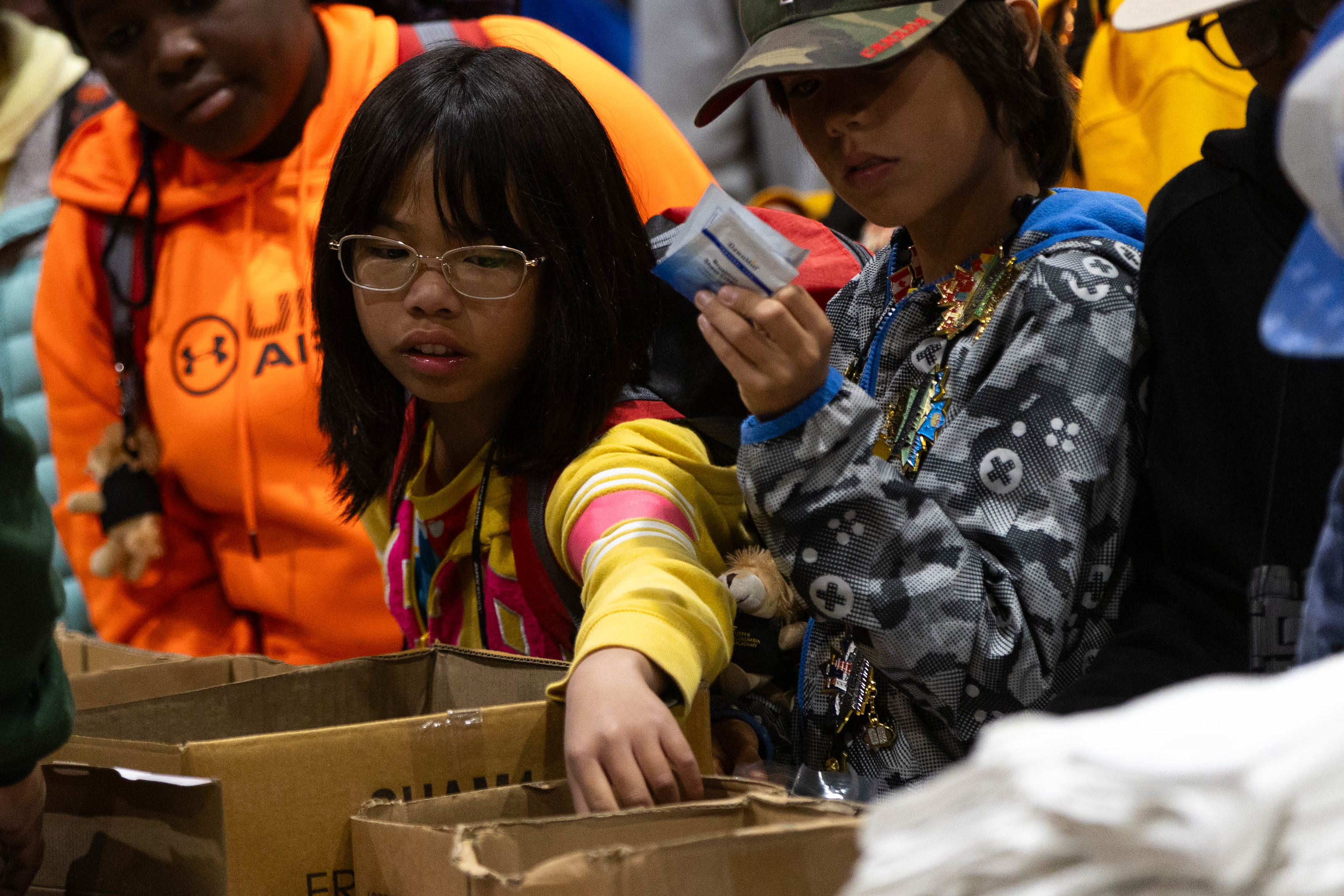 Children of diverse ethnicities create hygiene kits for the community. 
