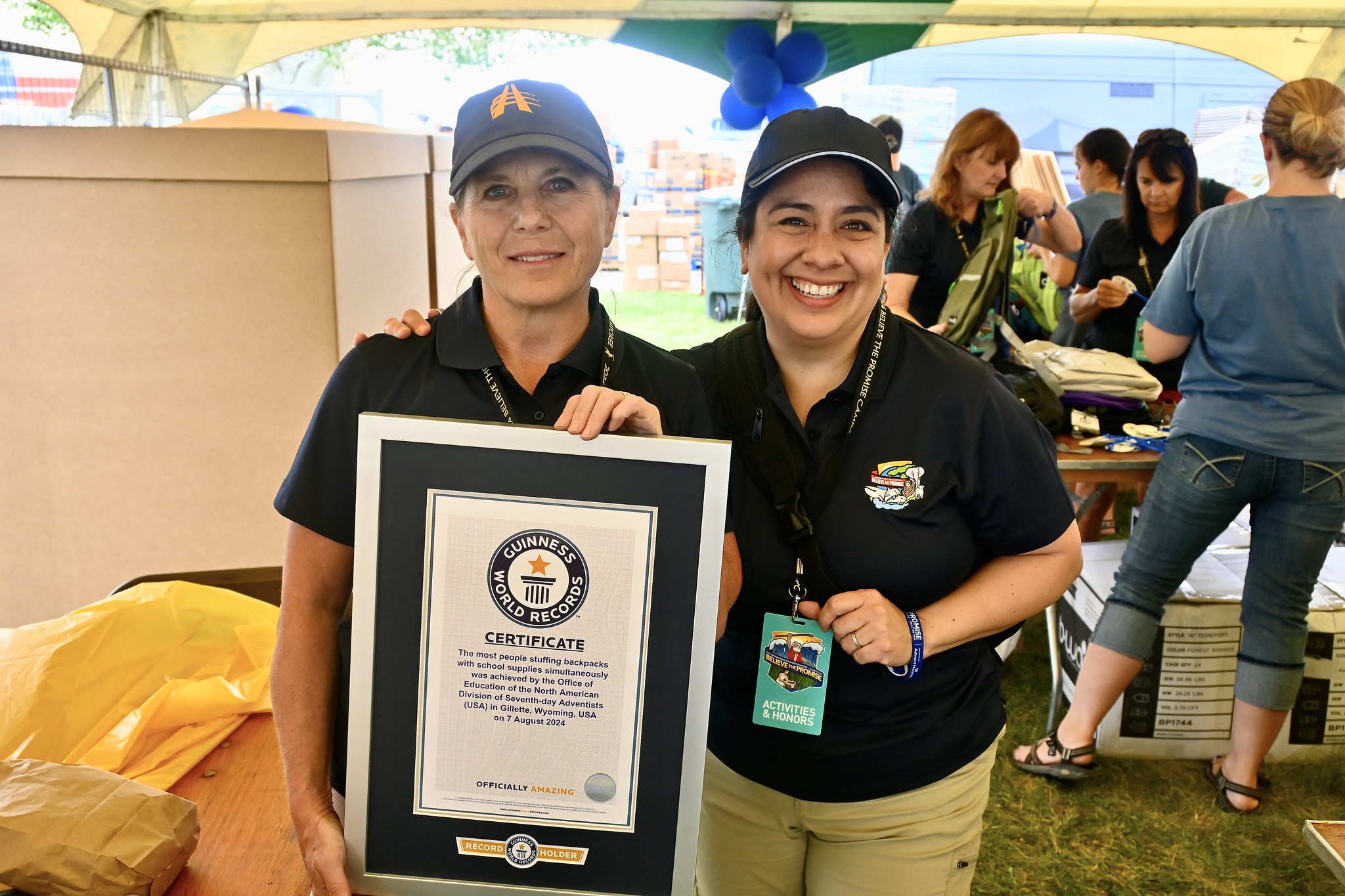 Organizers Nicole Mattson, Lake Union Conference associate superintendent of education, and Ruth Nino, Columbia Union Conference assistant director for early childhood education, are pictured holding the official Guinness World Records certificate after a successful attempt to stuff the most backpacks simultaneously. Photo: Cerron Pollard | North American Division