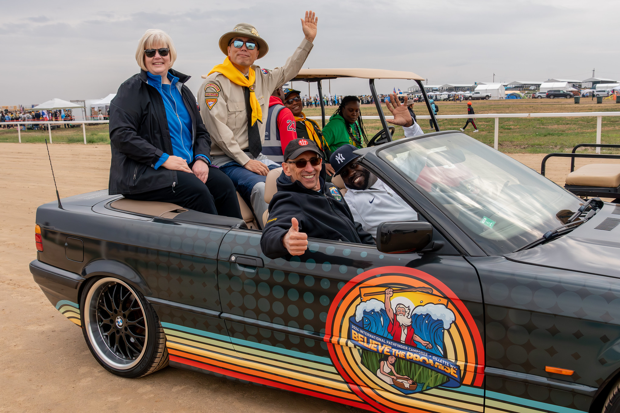5.&nbsp;&nbsp;&nbsp;&nbsp;  Vandeon Griffin, NAD Youth and Young Adult Ministries associate director, drives his renovated 1997 BMW 318i at the head of the international Pathfinder camporee parade on Thursday, August 8, 2924. He is accompanied by Tracy Young, NAD Youth and Young Adult Ministries director, (seated beside him), Kyoshin Ahn, NAD executive secretary, and Judy Glass, NAD treasurer/CFO. Photo: Art Brondo | North American Division