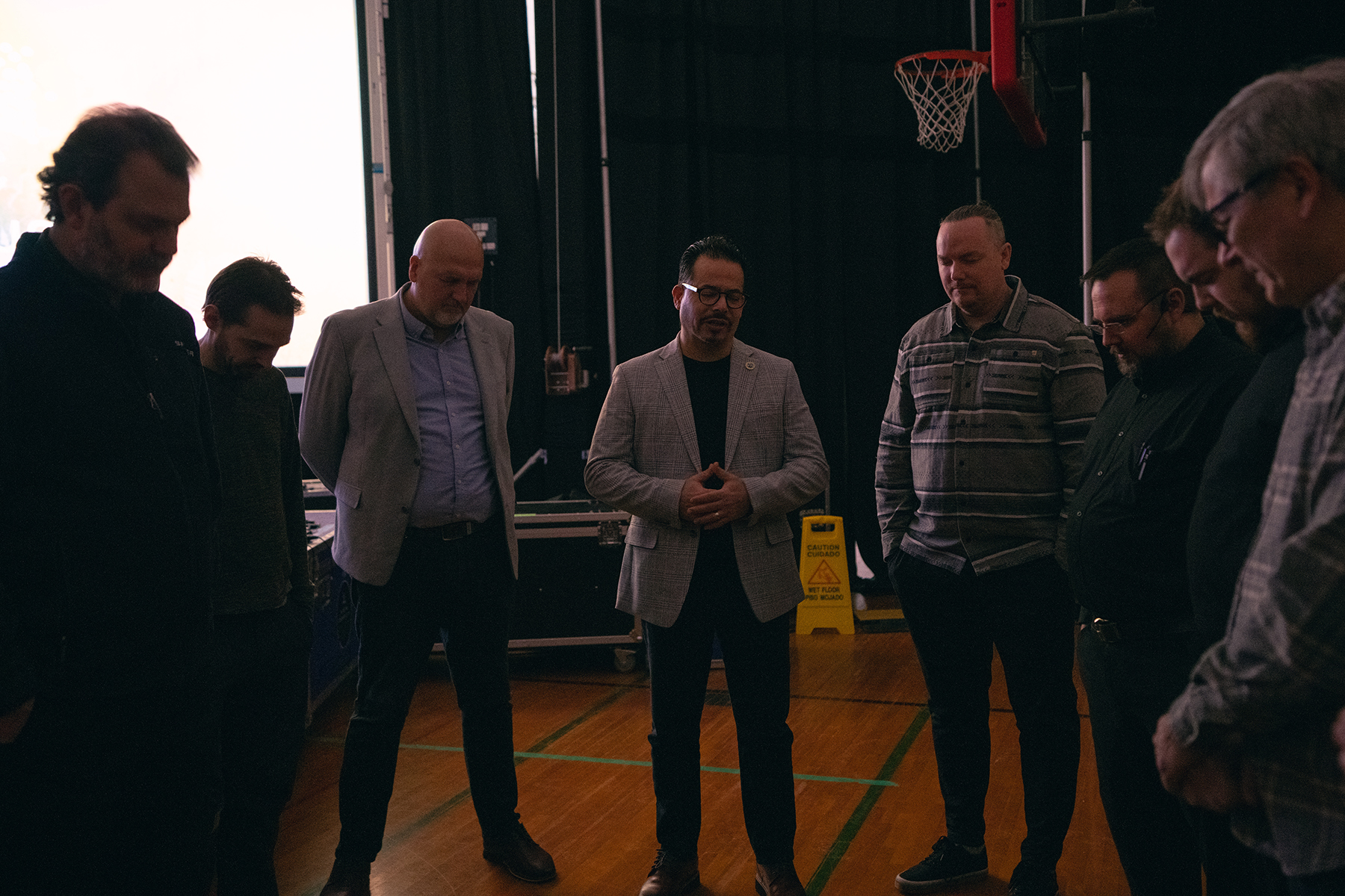 Diverse group of men praying together
