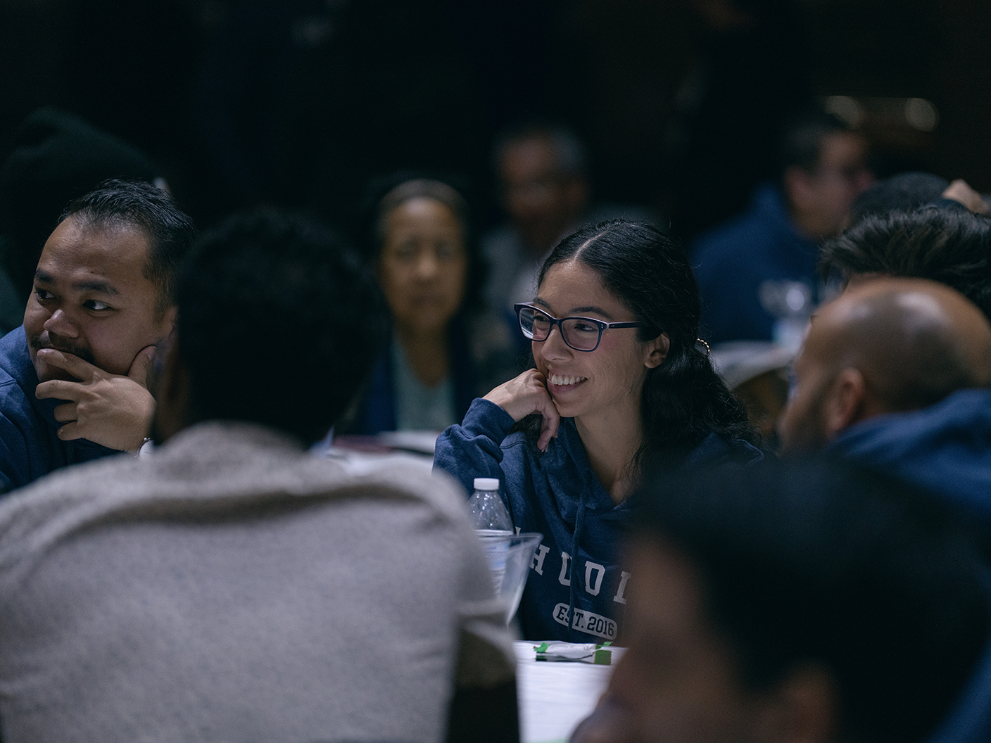 A diverse group of people listen intently at a conference.