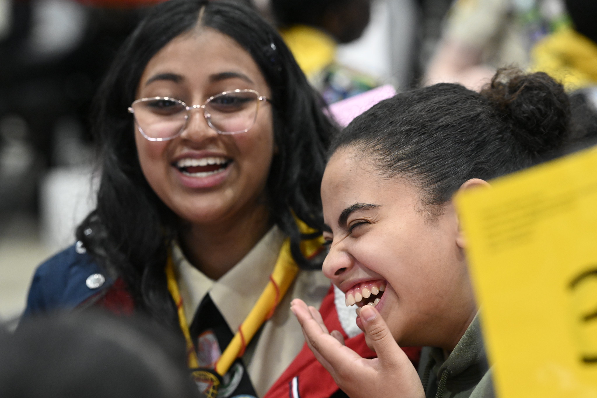 Two girls laughing at a competition table during PBE.