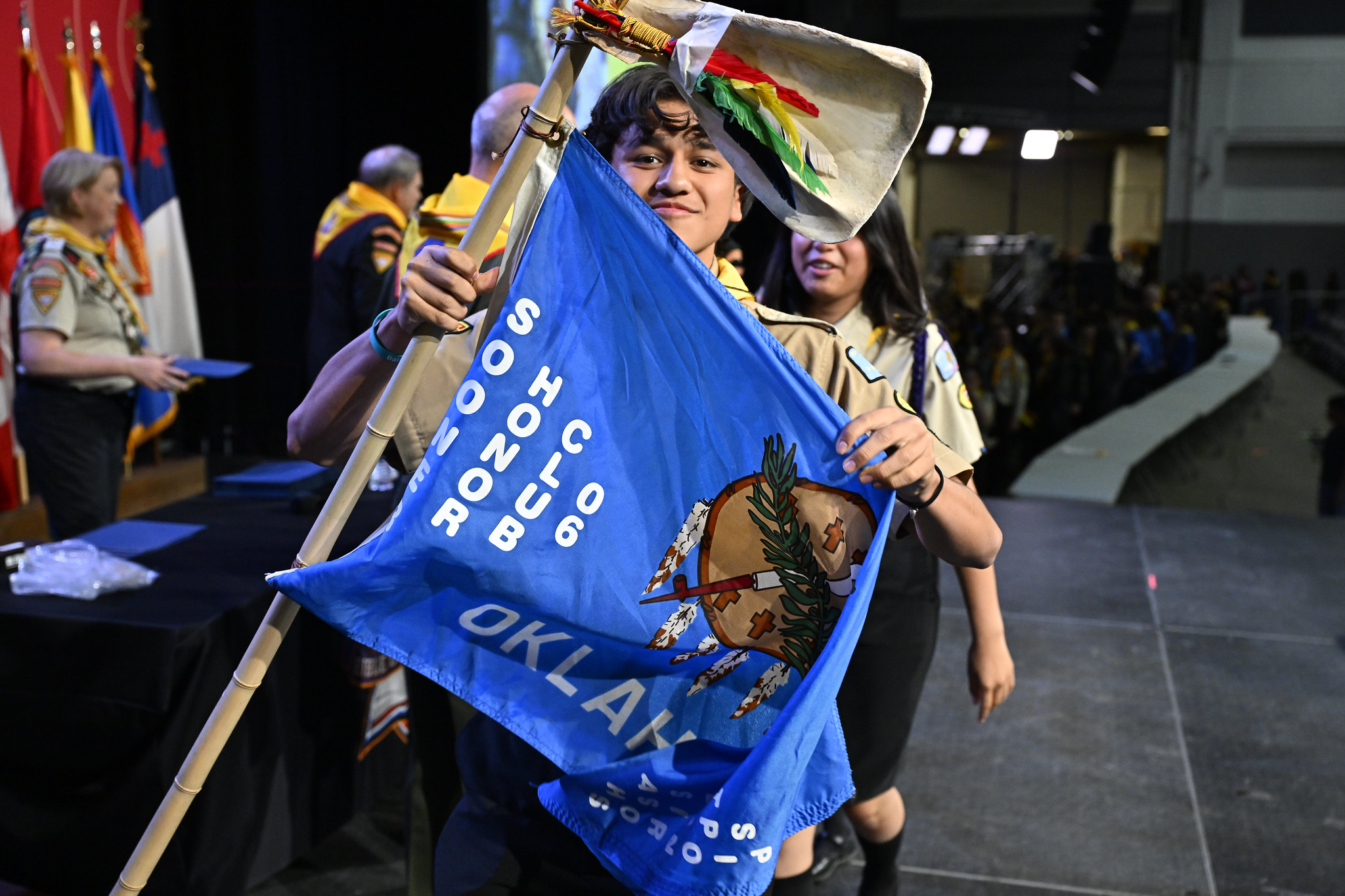 A young Pathfinder holds up a flag representing his club during the awards ceremony