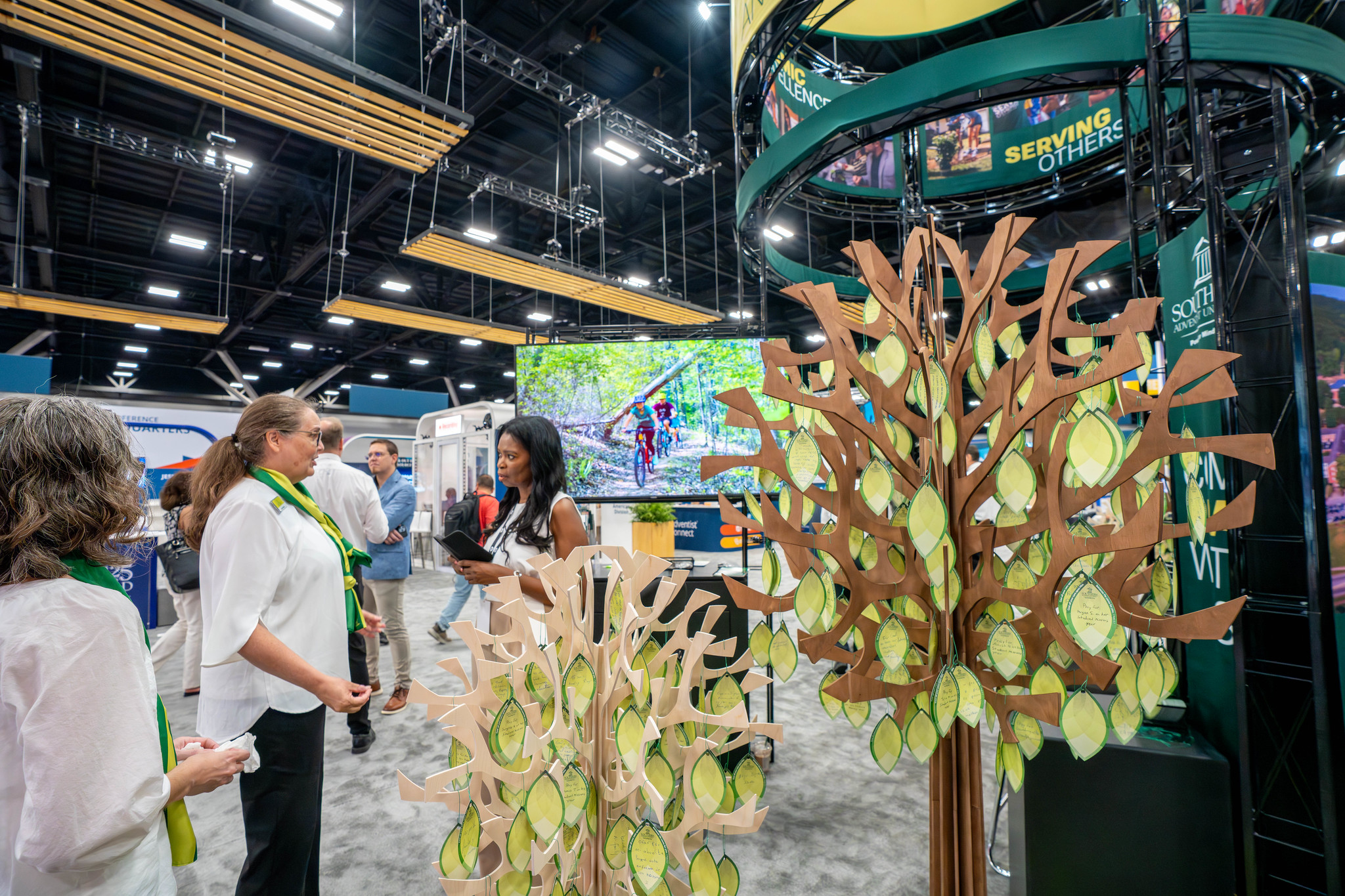 Herma Percy talks with representatives at the Southern Adventist University exhibit booth.