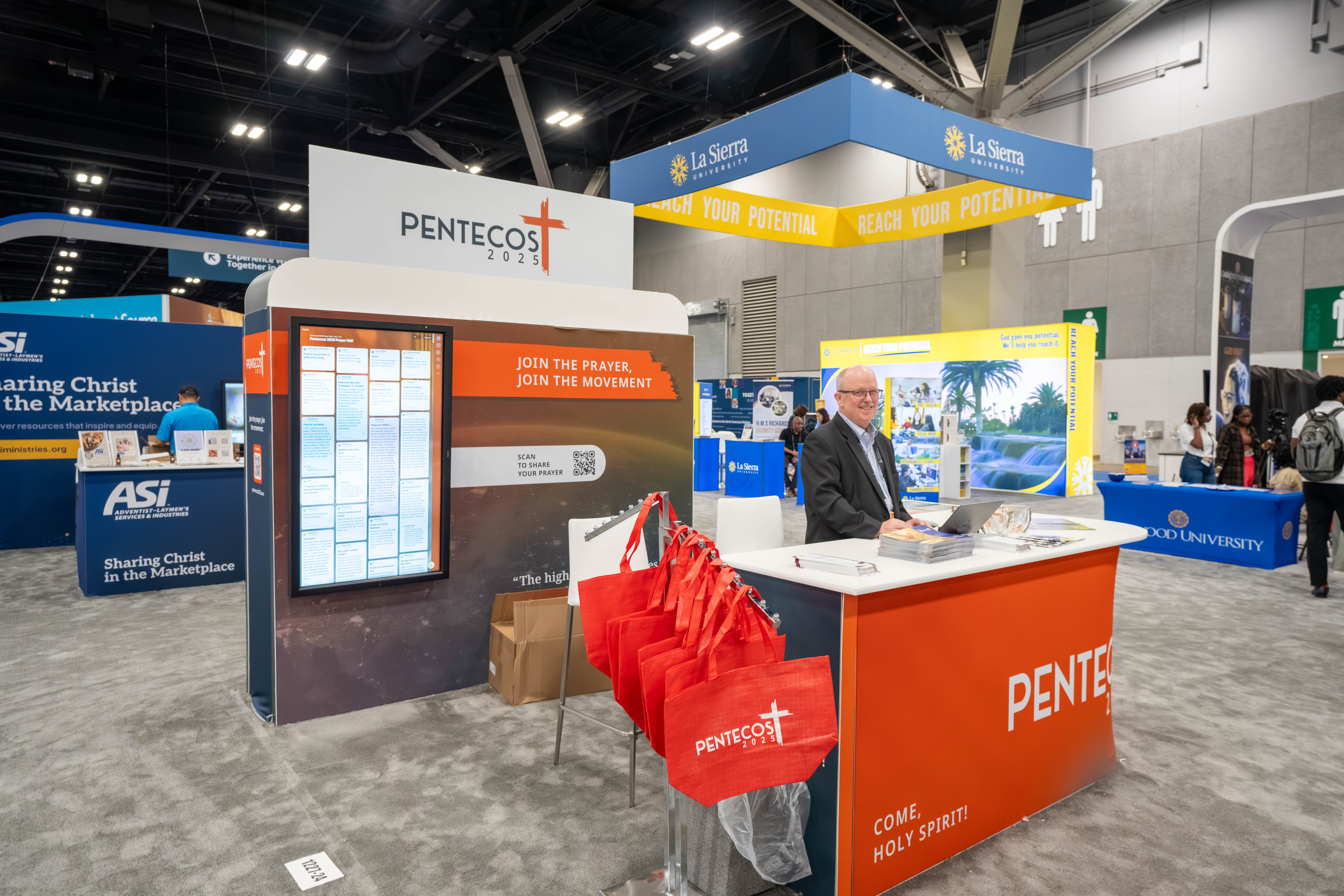 Man poses at the Pentecost 2025 booth.