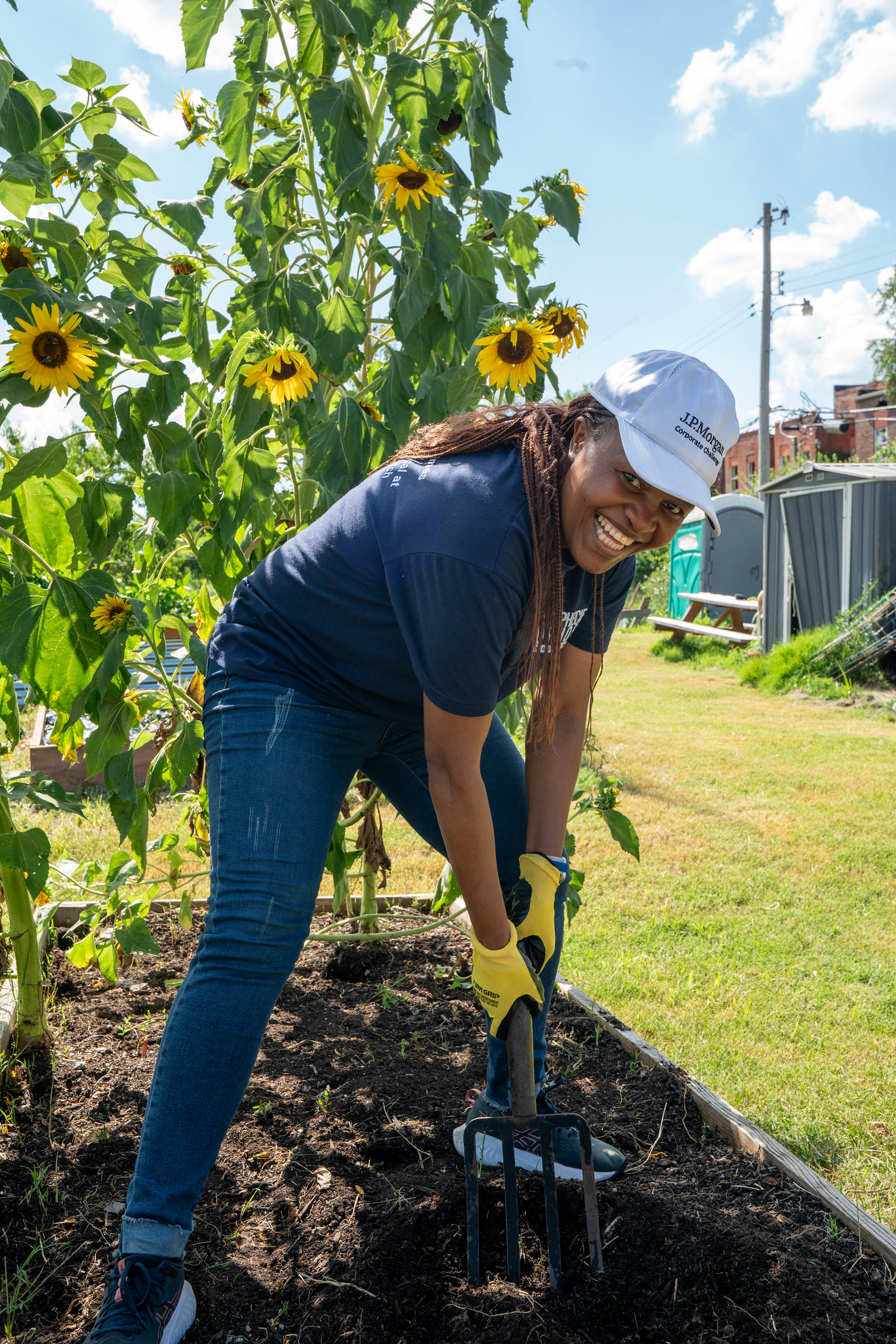 A smiling volunteer raking the soil. 