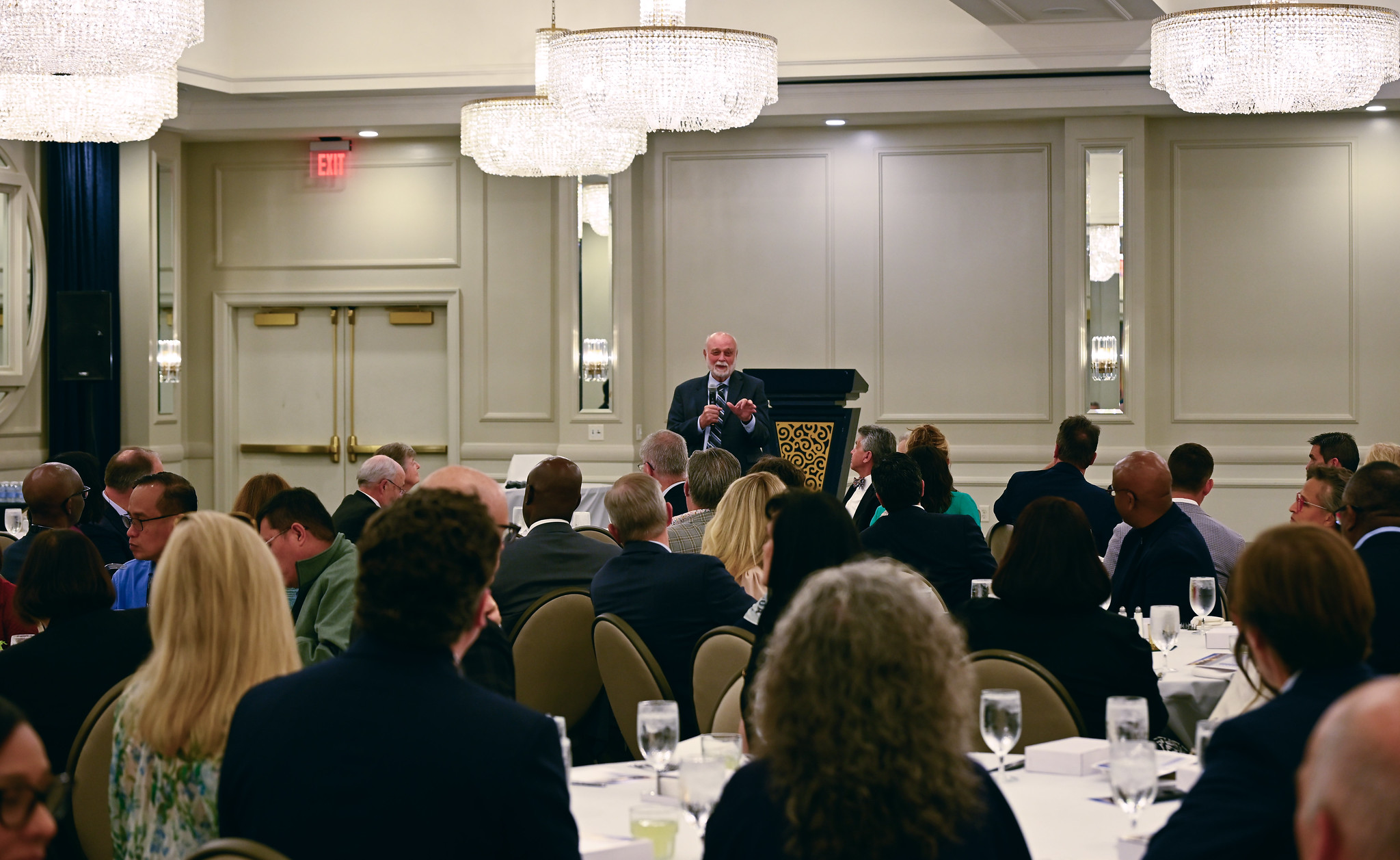 room with people eating and talking at a convention site at hotel