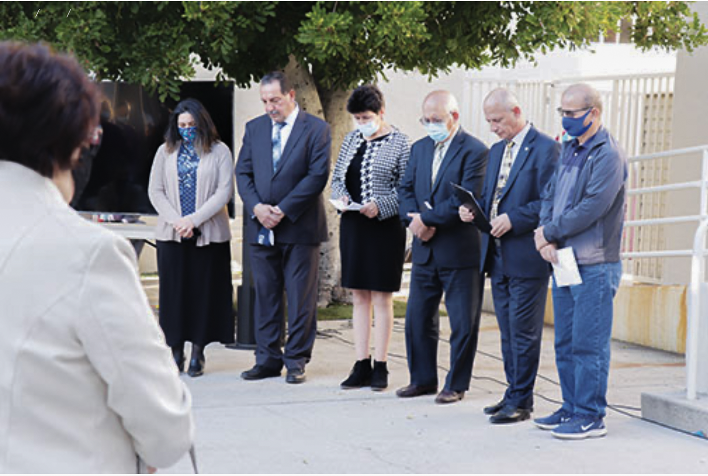 Group of people in formal attire praying.