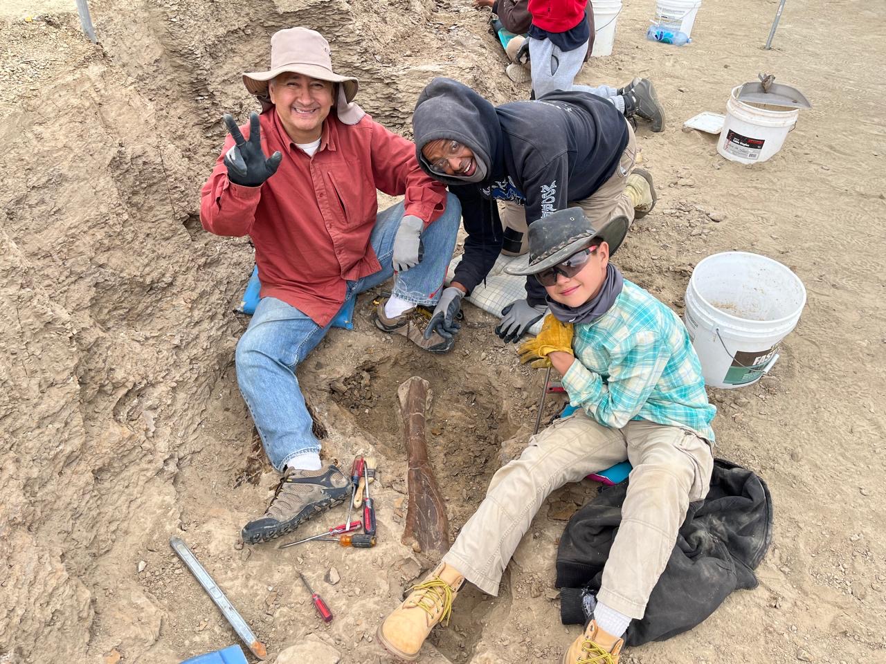 Two men and a boy at an excavation site. 
