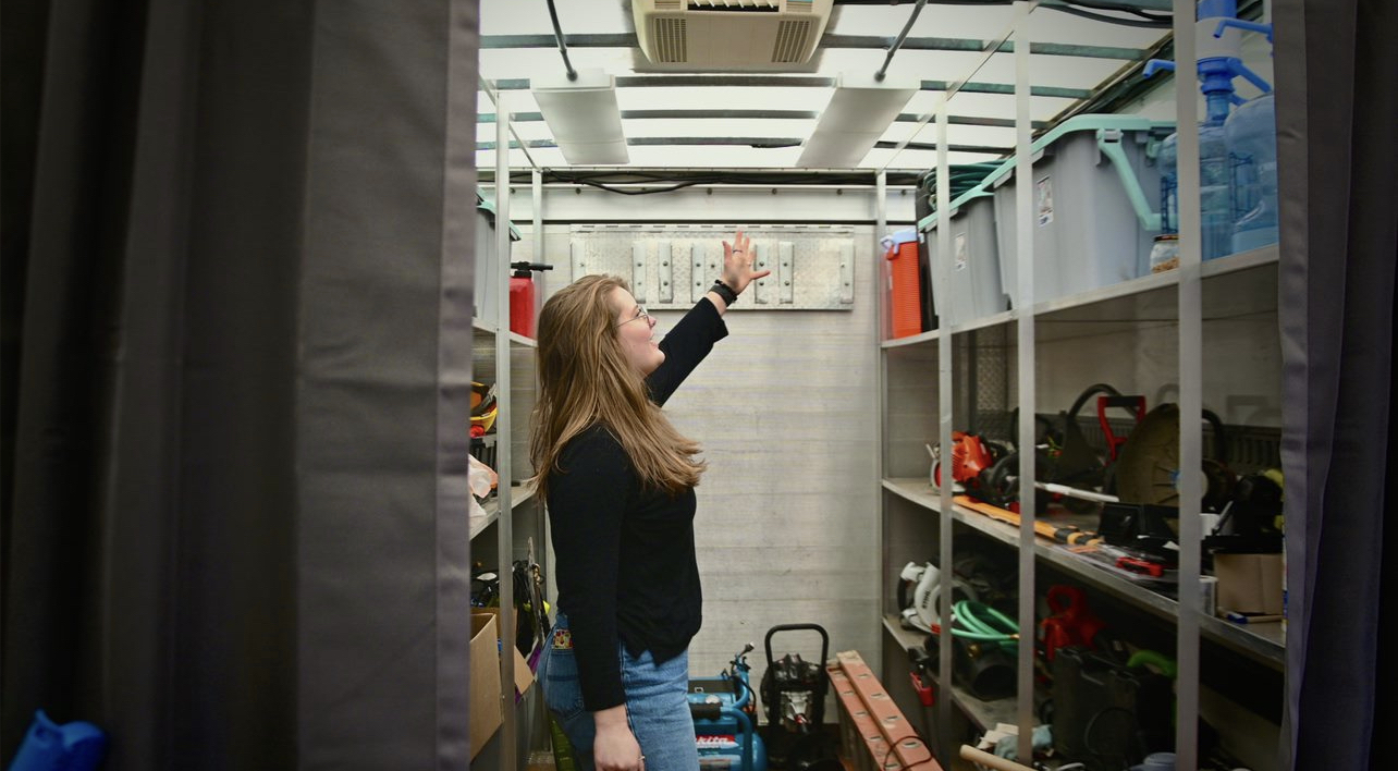 A young woman standing inside a trailer surrounded by tools. The trailer houses the Walla Walla Tool Library.