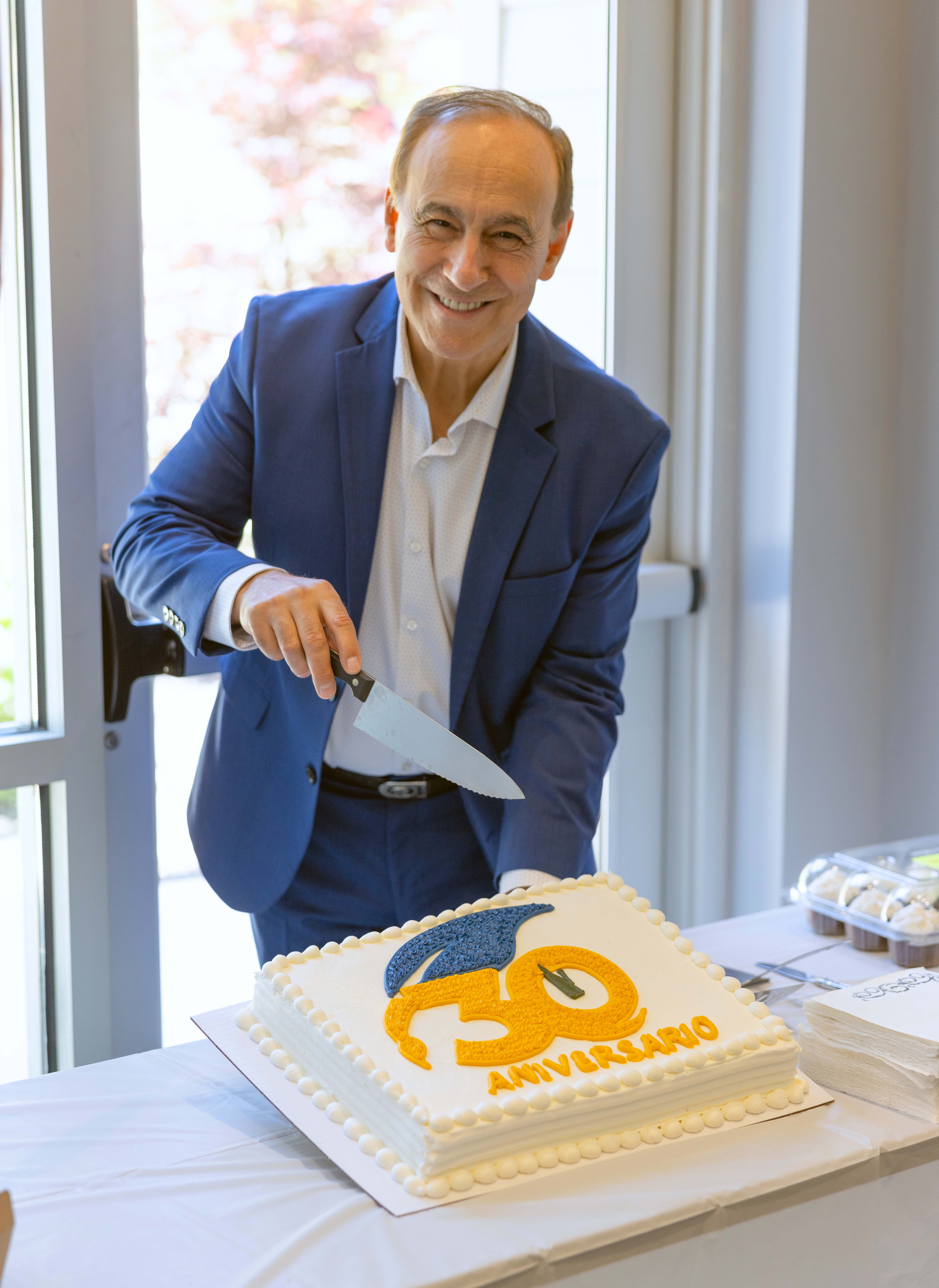 Pastor Robert Costa prepares to cut the anniversary cake.