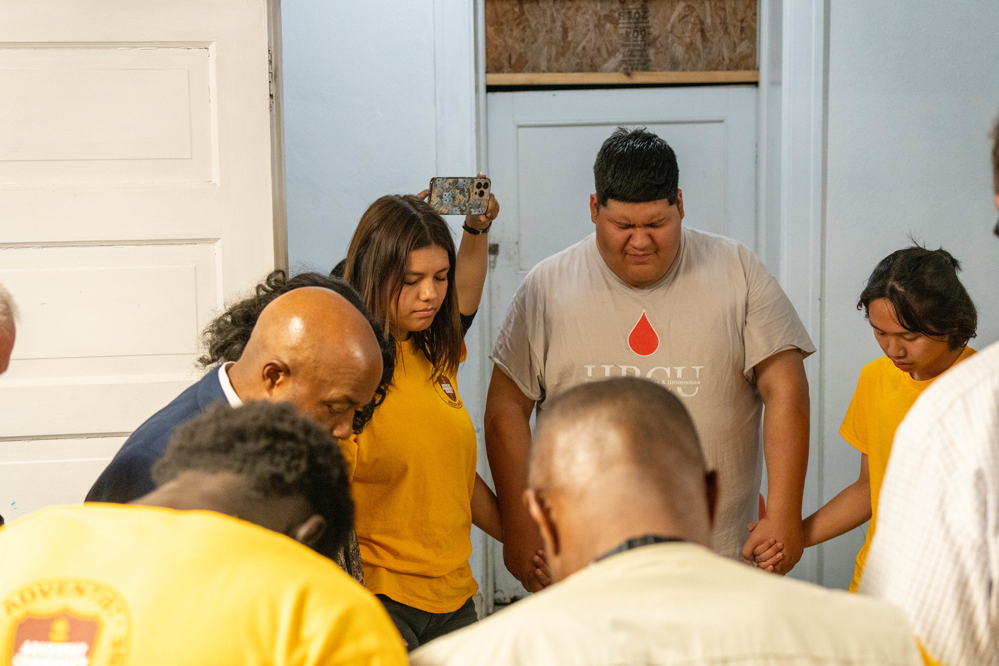group of volunteers pray before helping St. Louis residents in community service