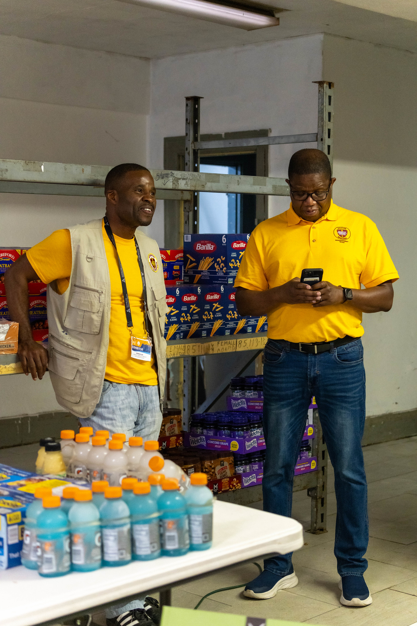 Derrick Lea, NAD ACS director, and Tyrone Douglas, Mid-America Union ACS director, make the most of a quiet moment before the tornado relief goods distribution gets into full swing.
