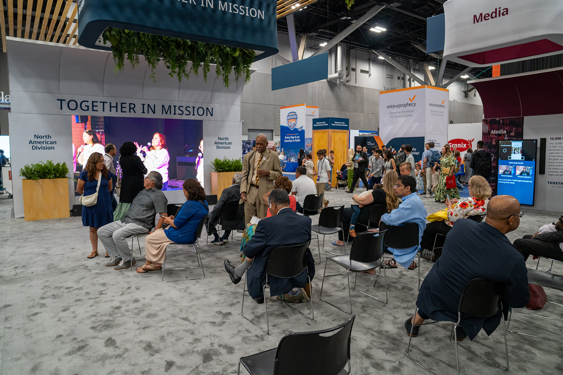 A picture of people sitting in video showcase area of NAD exhibit