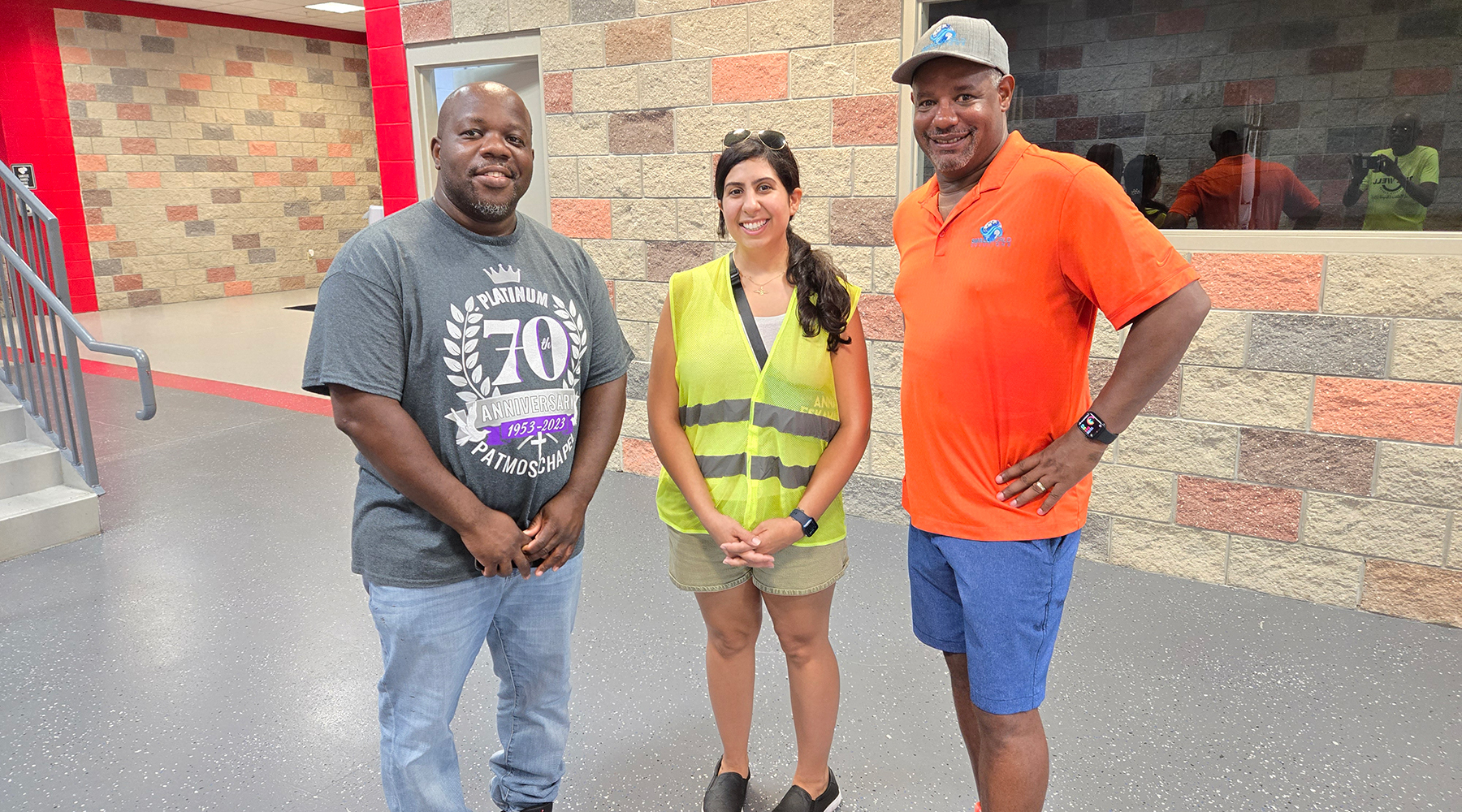 Two men and a woman pose inside a church.