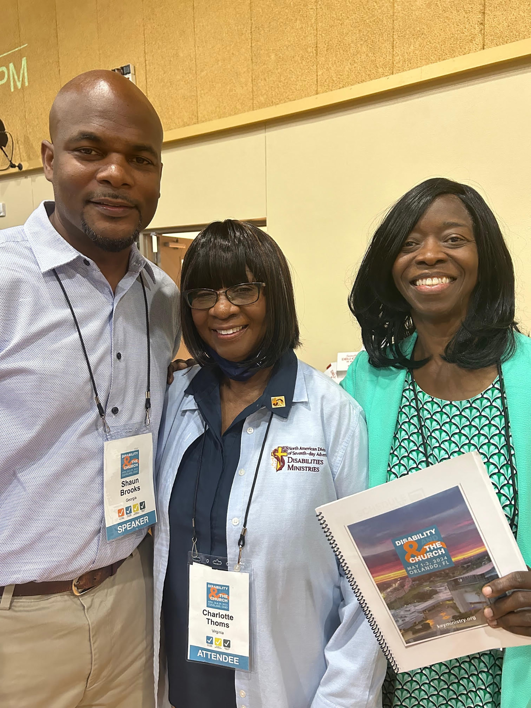 Photo of a black man and two black women dressed in business casual at a conference