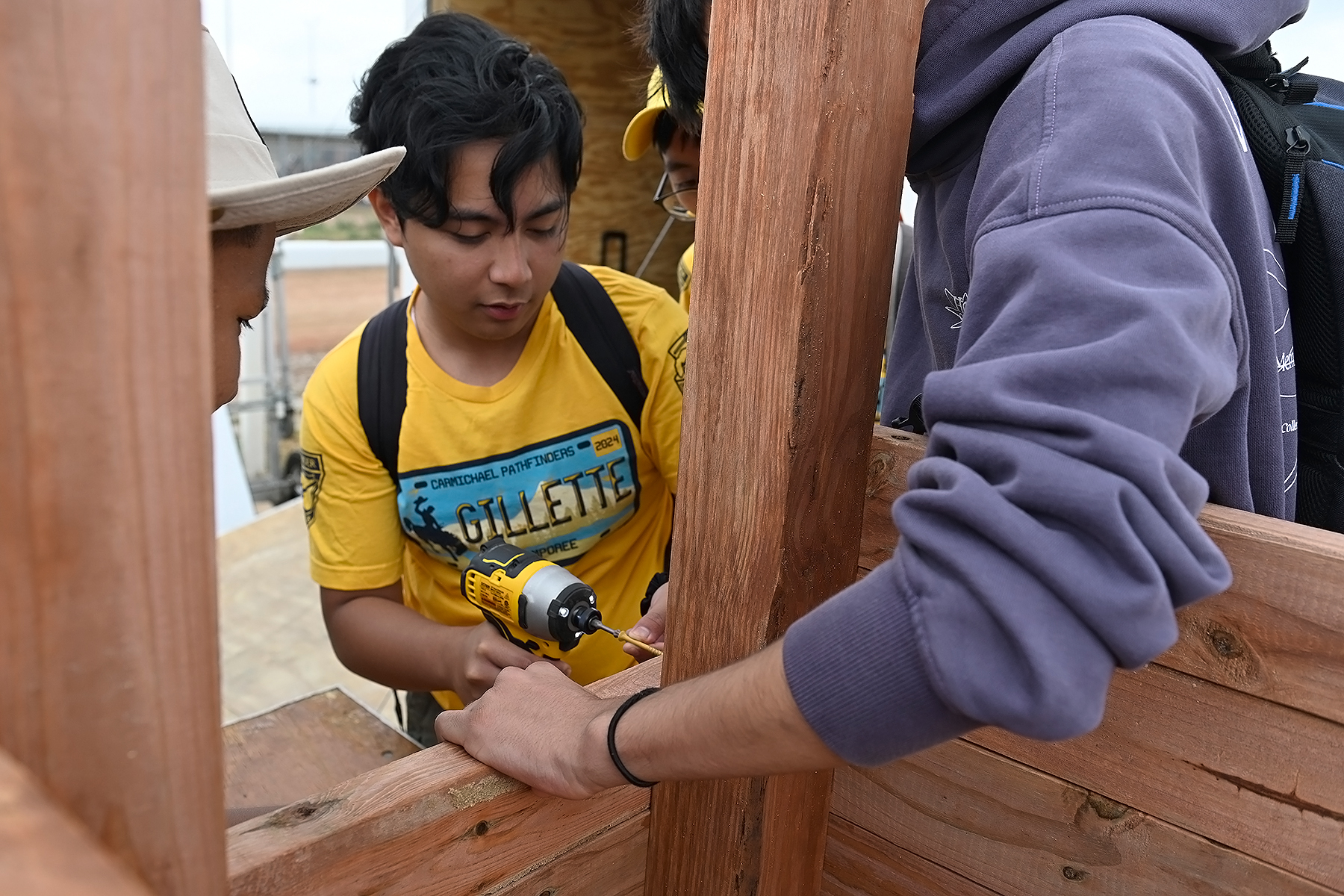 A group of teenage boys building a grow box together. 