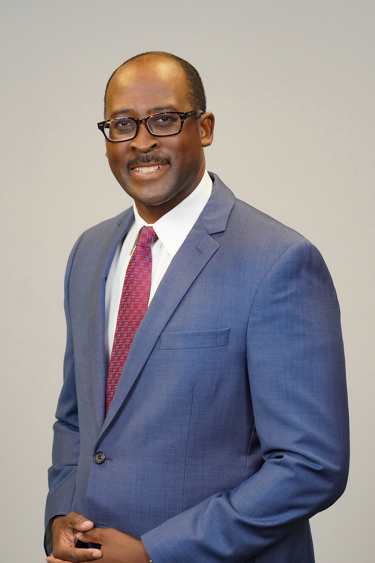 Headshot of a smiling black man in a suit