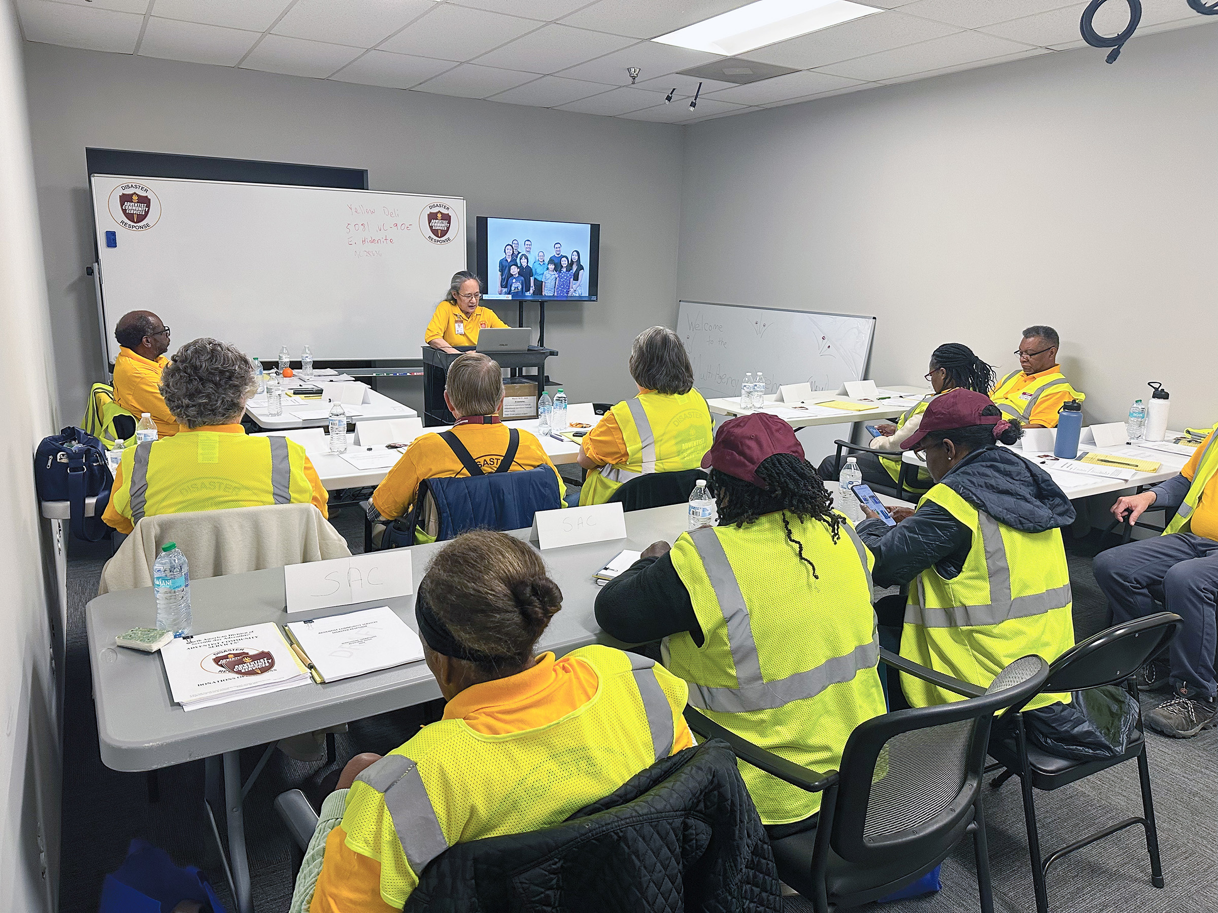 ACS classroom with teacher at front and students wearing yellow safety vests