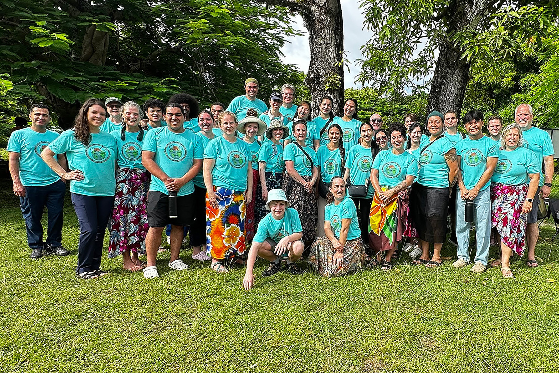 Group photo of people in green t-shirts outside in Fiji