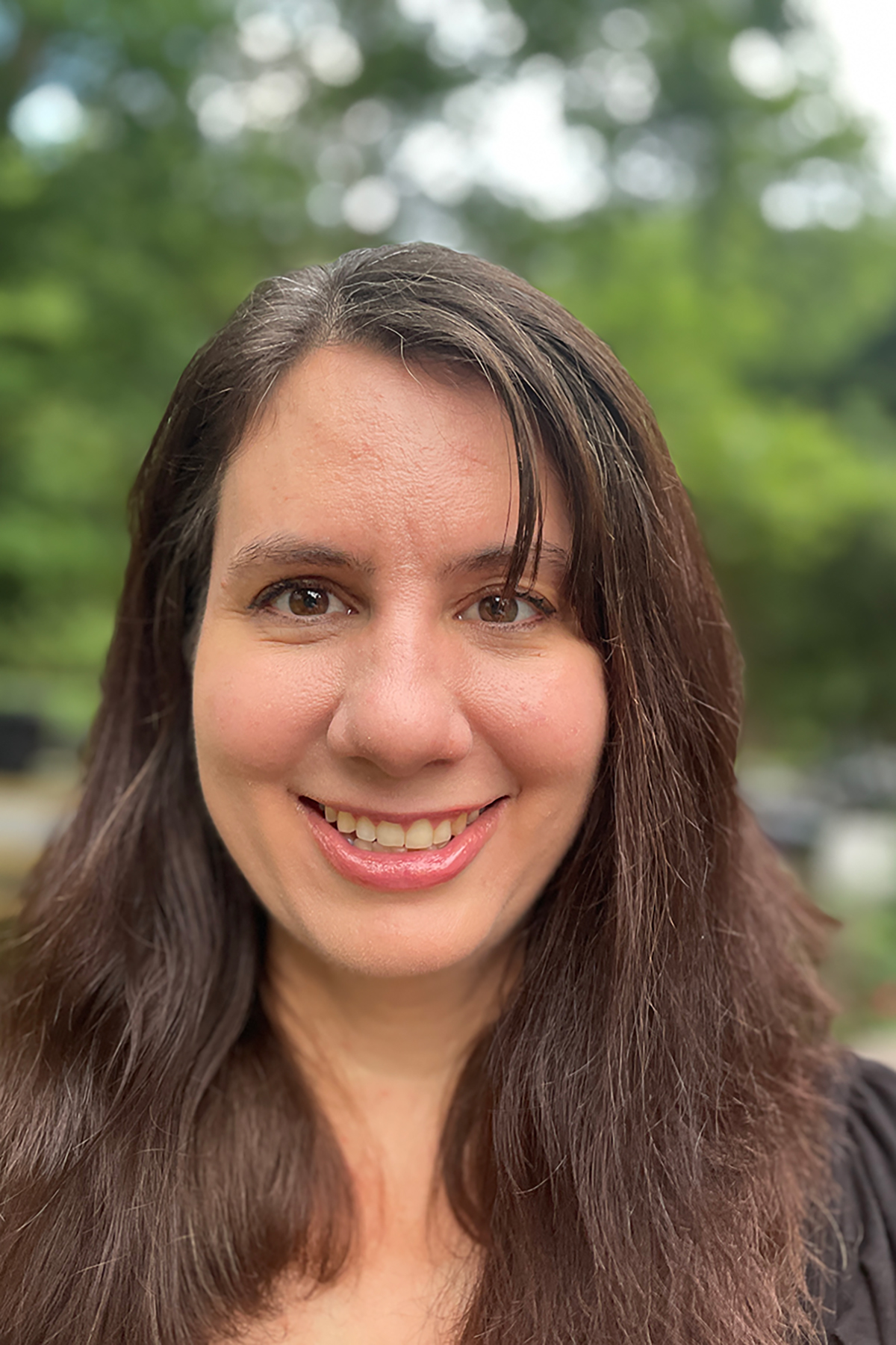 A headshot of a smiling woman