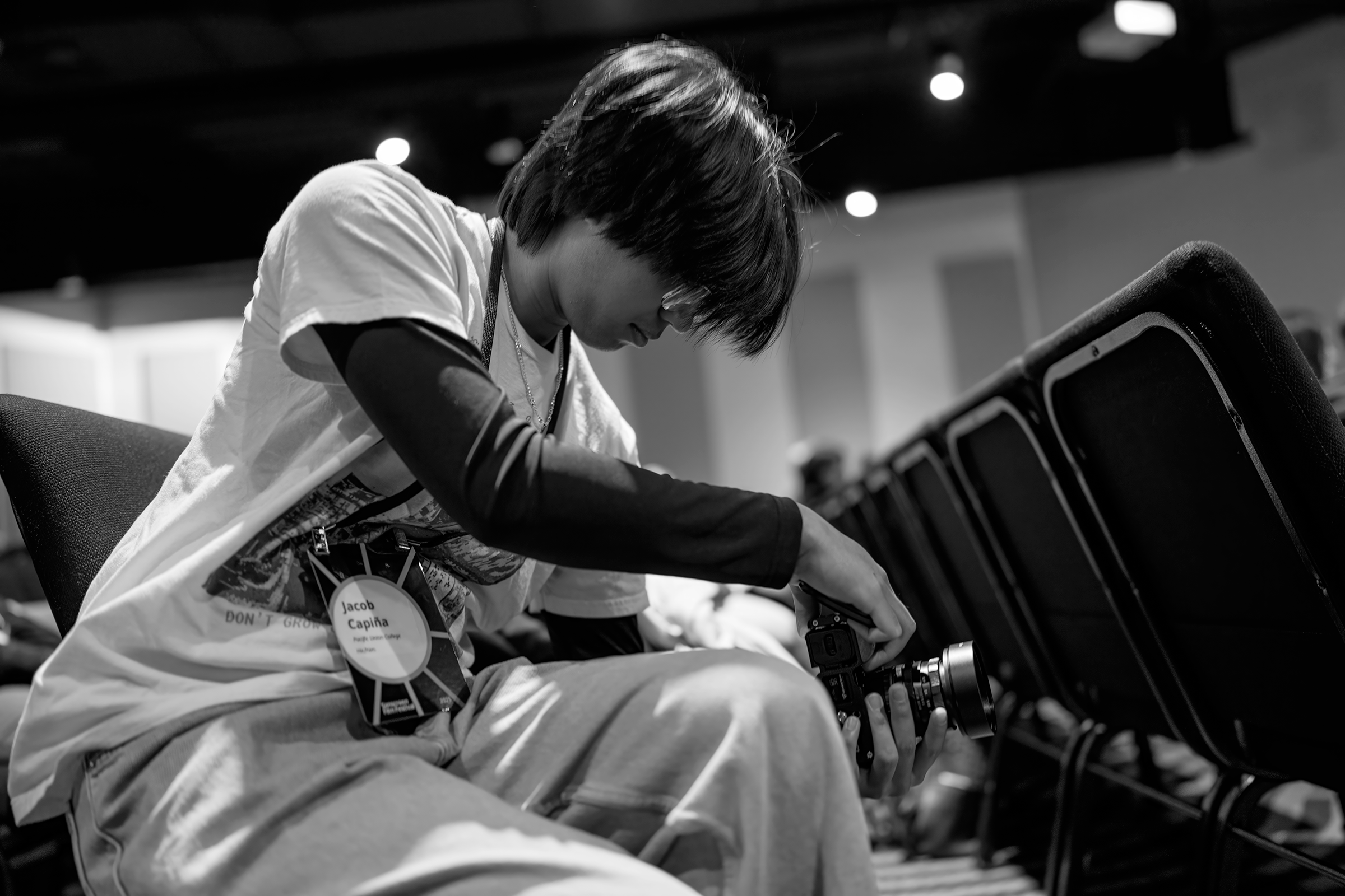 Black and white photo of Jacob Capina taking a photo at Sonscreen Film Festival. 