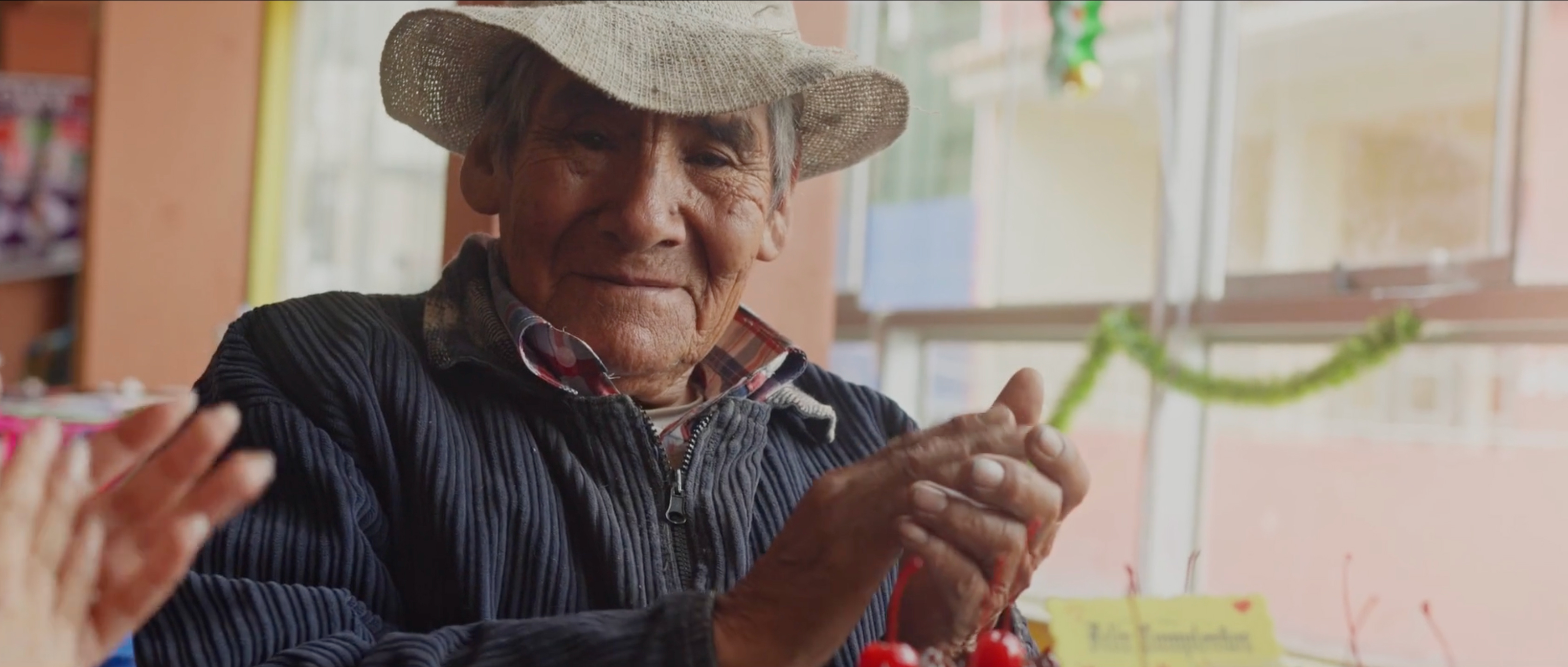 Screenshot of elderly Peruvian man clapping his hands