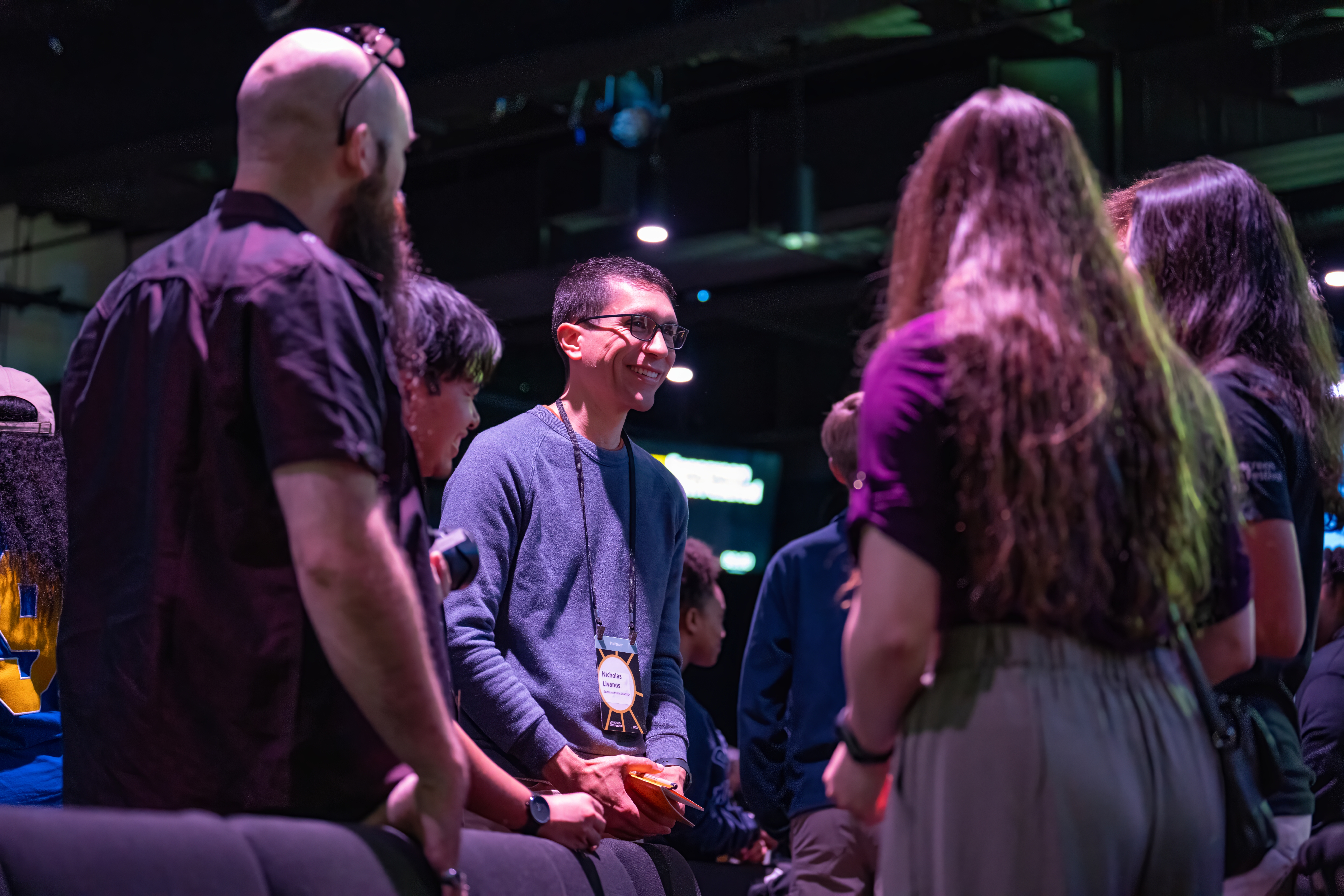 A candid photo of people smiling and standing in a circle