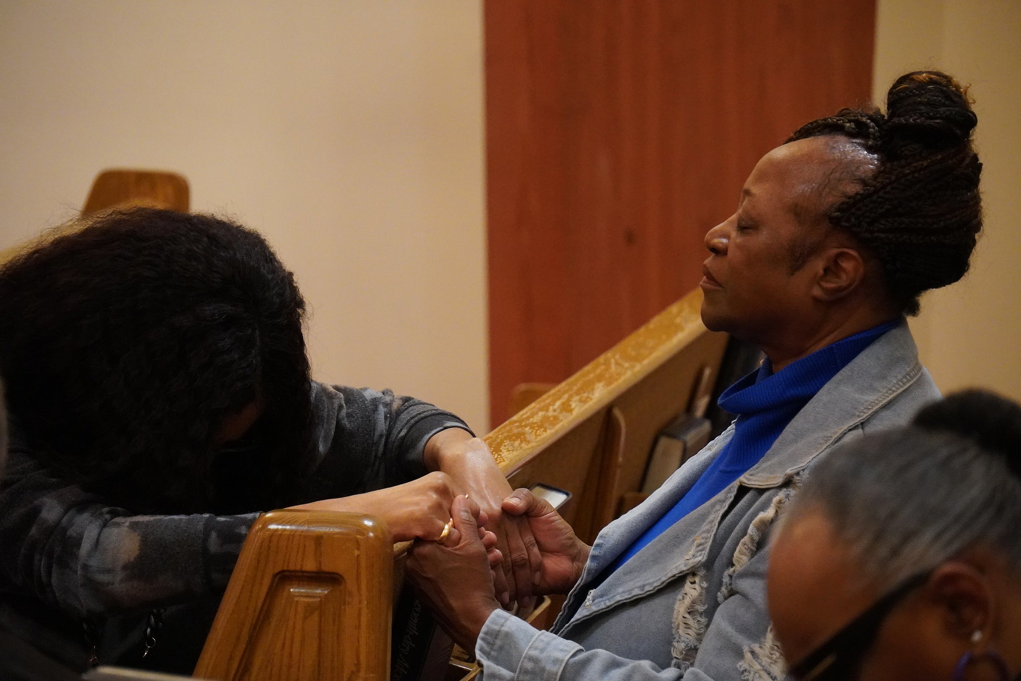 two women in prayer in church setting