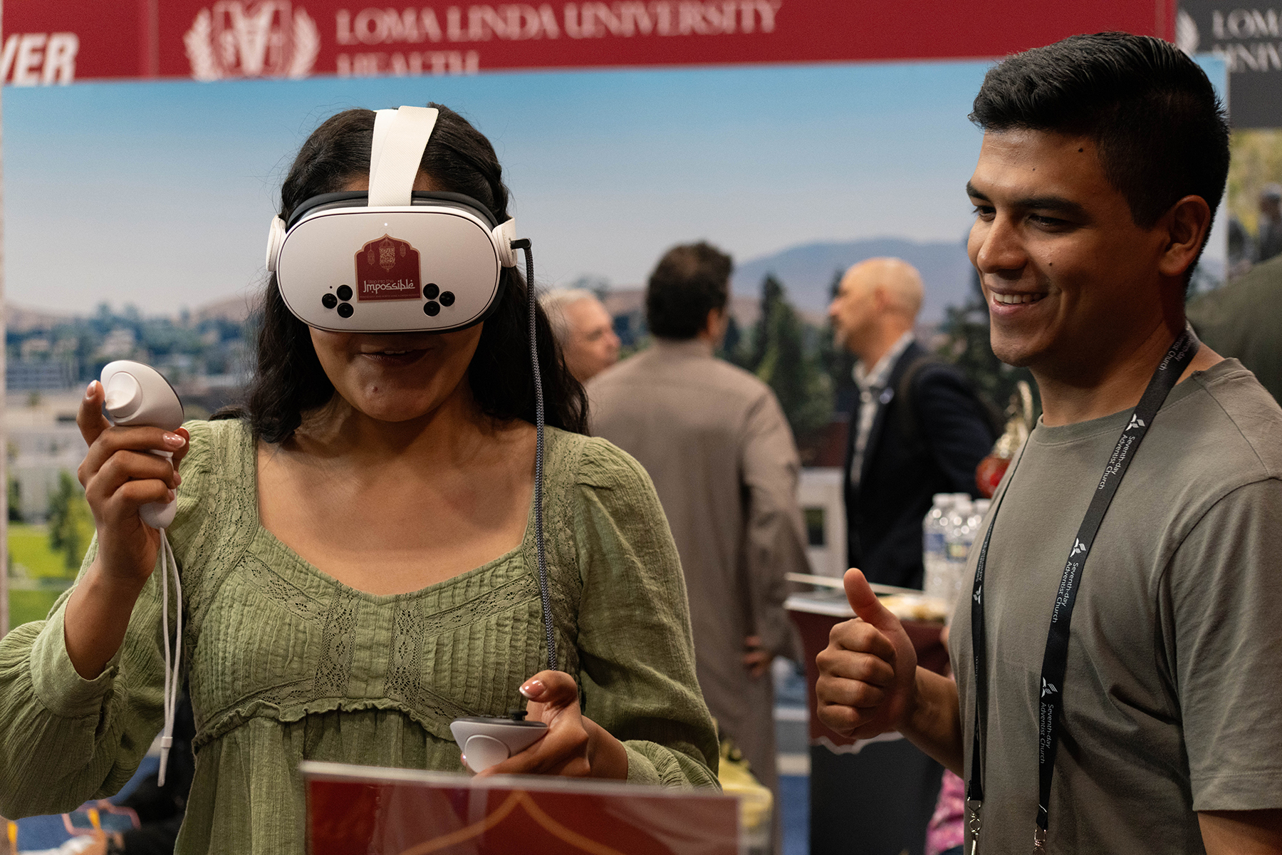 A young woman wears a VR headset as a young man looks on
